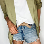 Handmade women's tie belt made from biodegradable materials, styled on a natural fabric background.