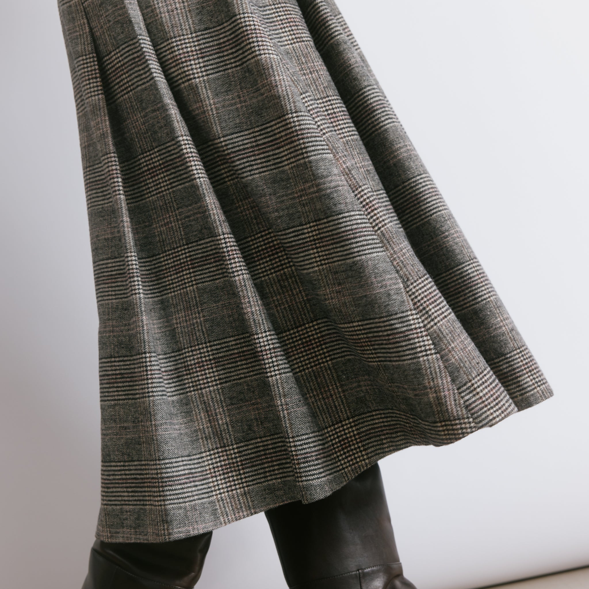 Structured pleated check skirt designed as a versatile statement piece, perfect for day to evening wear.
