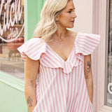 Close-up of ruffle neckline detail on a V-neck cotton summer dress with A-line maxi skirt.
