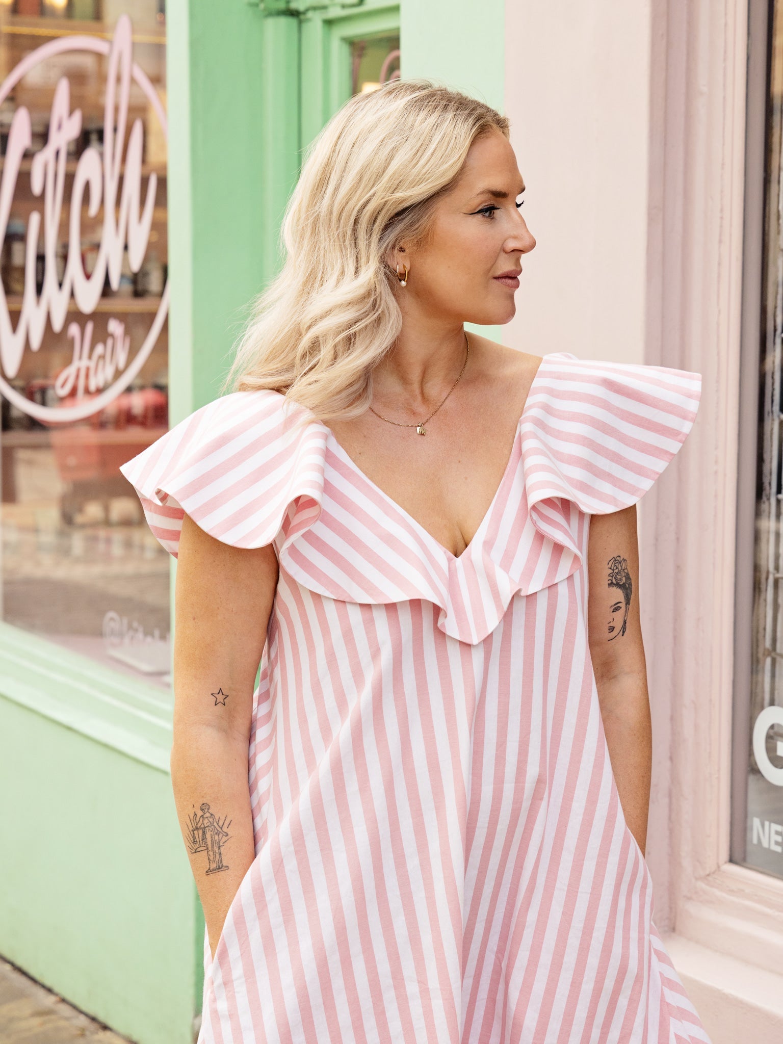 Close-up of ruffle neckline detail on a V-neck cotton summer dress with A-line maxi skirt.
