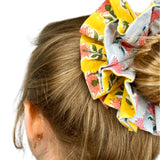 Green oversized scrunchie with floral pattern, perfect for adding color to hairstyles.
