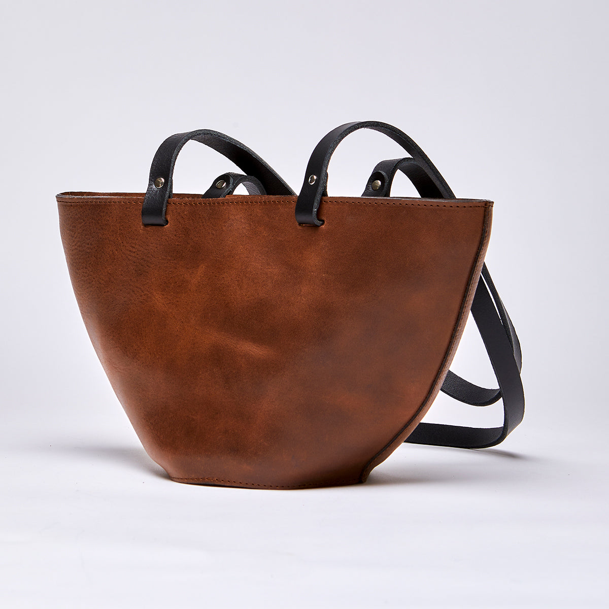 Brown leather handbag with smooth finish and elegant design, perfect as an upcycled leather accessory