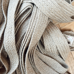 Natural fiber tie belt displayed on rustic background emphasizing eco-friendly design.