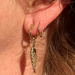 Close-up of gold plated mini hoops highlighting smooth polished finish.