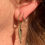 Close-up of gold plated mini hoops highlighting smooth polished finish.