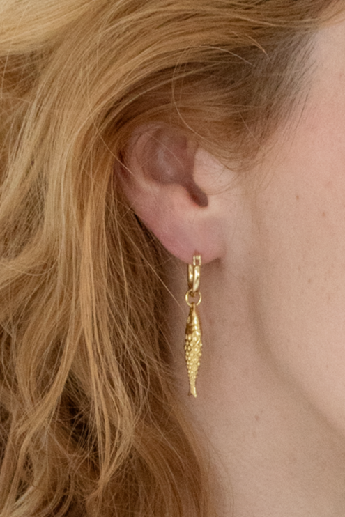 Detailed shot of gold plated mini hoops showcasing their petite size and shine.