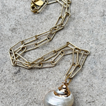 Gold plated necklace featuring a delicate single shell pendant on a fine chain.