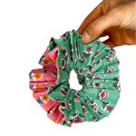Green oversized scrunchie styled in a loose bun, highlighting the floral pattern.