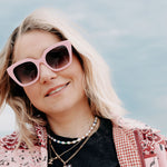 Pink sunglasses with UV protection and fashionable design elements.