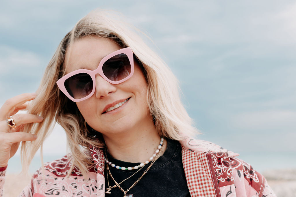 Pink sunglasses with UV protection and fashionable design elements.