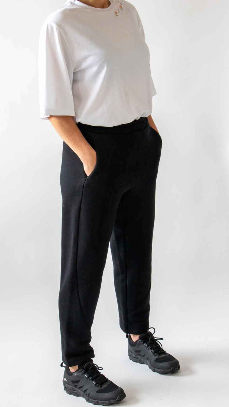 Close up of the woman with her hand in the pocket standing showing the front of the trousers