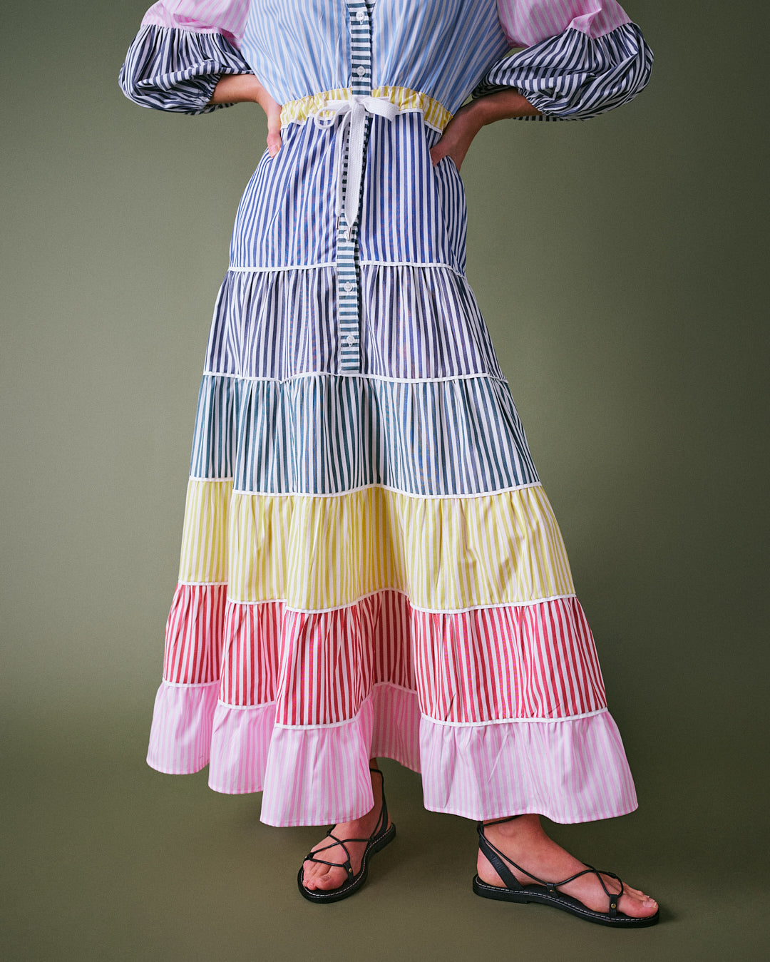 Button down summer dress featuring a V-neck, tiered skirt, and vibrant multicolour stripes.