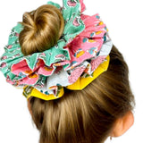 Close-up of a green floral scrunchie showing intricate flower patterns and texture.