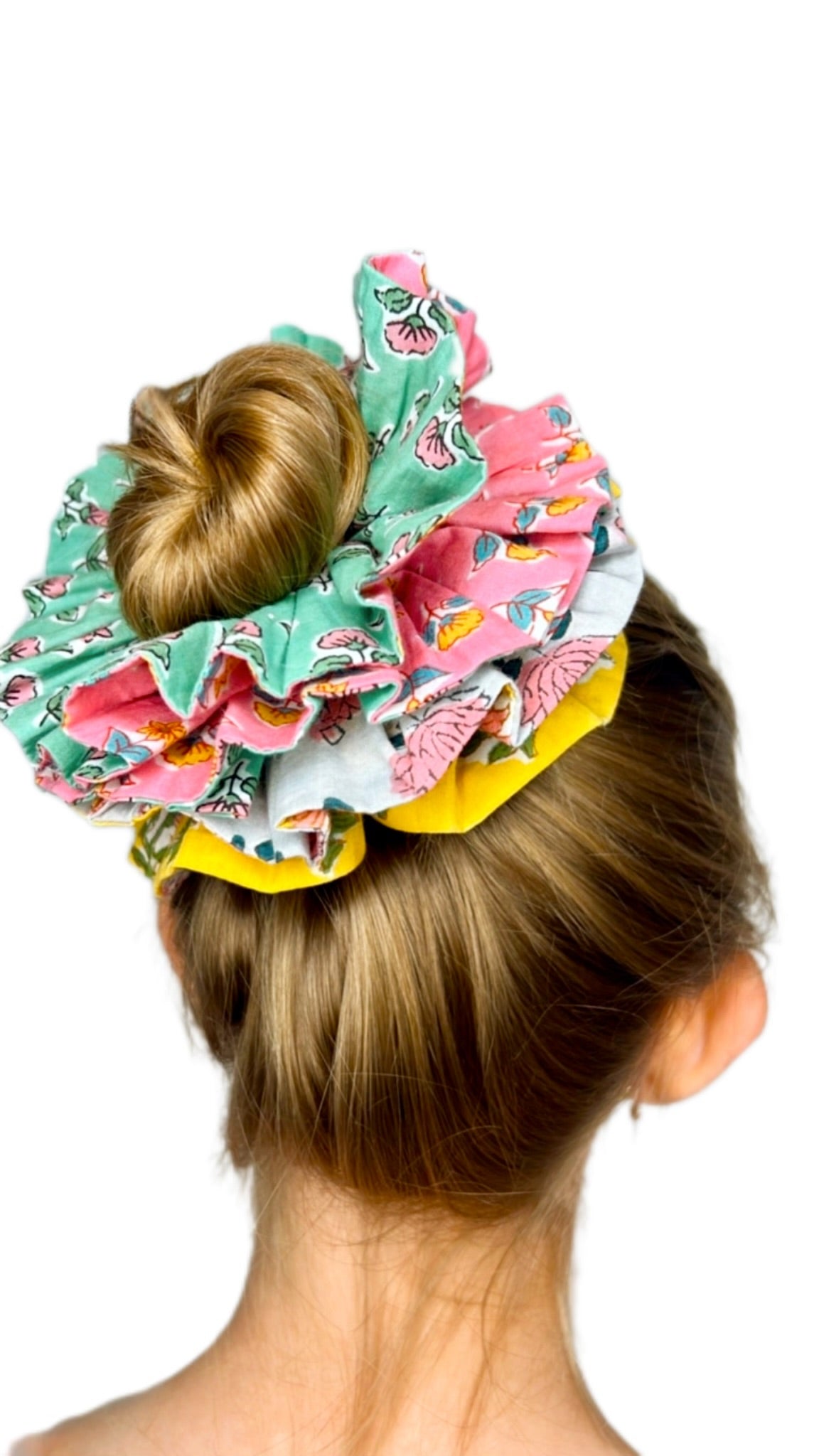 Close-up of a green floral scrunchie showing intricate flower patterns and texture.