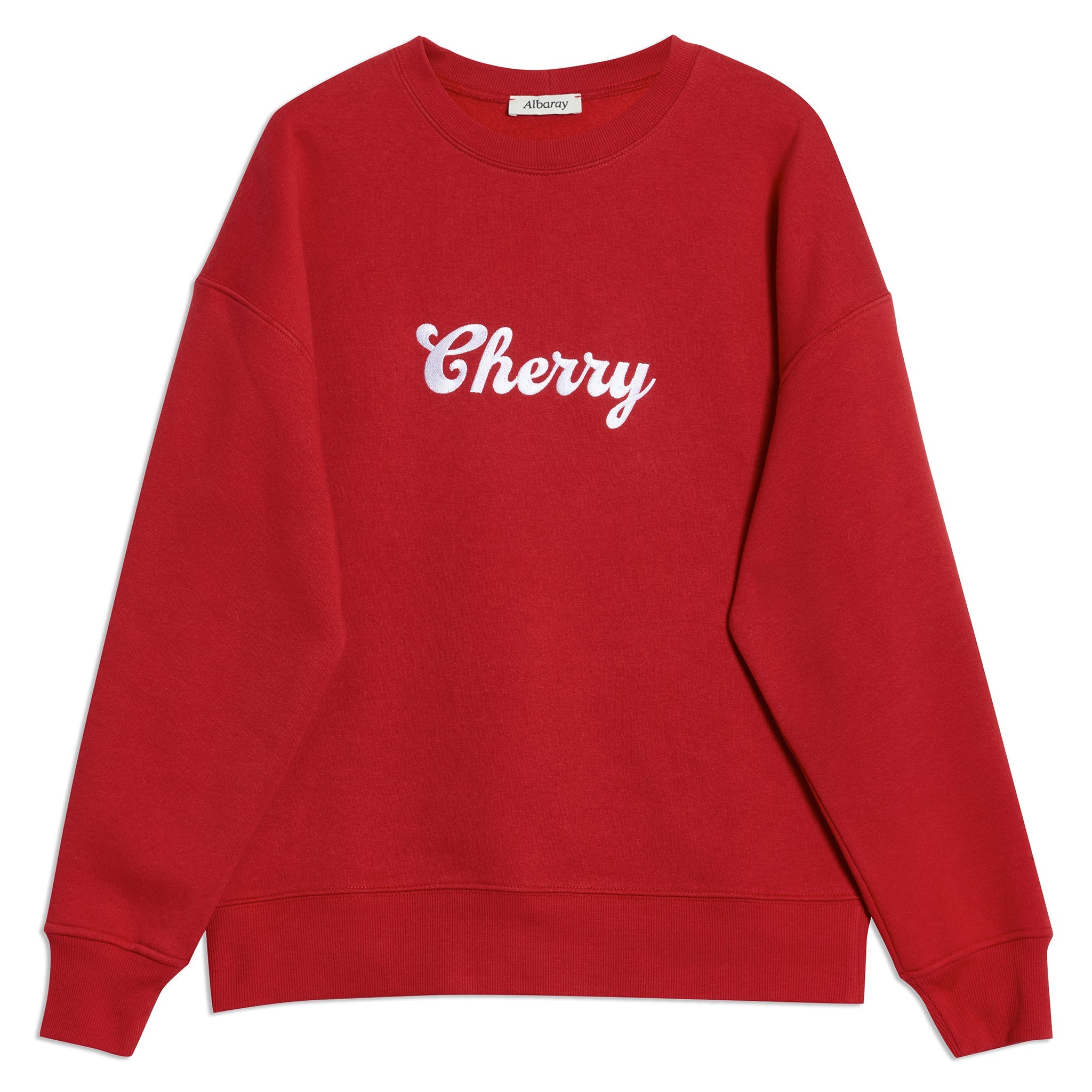 Red embroidered sweatshirt styled with casual outfit, featuring relaxed fit and embroidered slogan, soft fleece lining for warmth, ideal for comfortable winter casual wear.