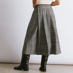 Check midi skirt with a fitted waist and deep structured pleats, creating a flattering silhouette for autumn winter.  