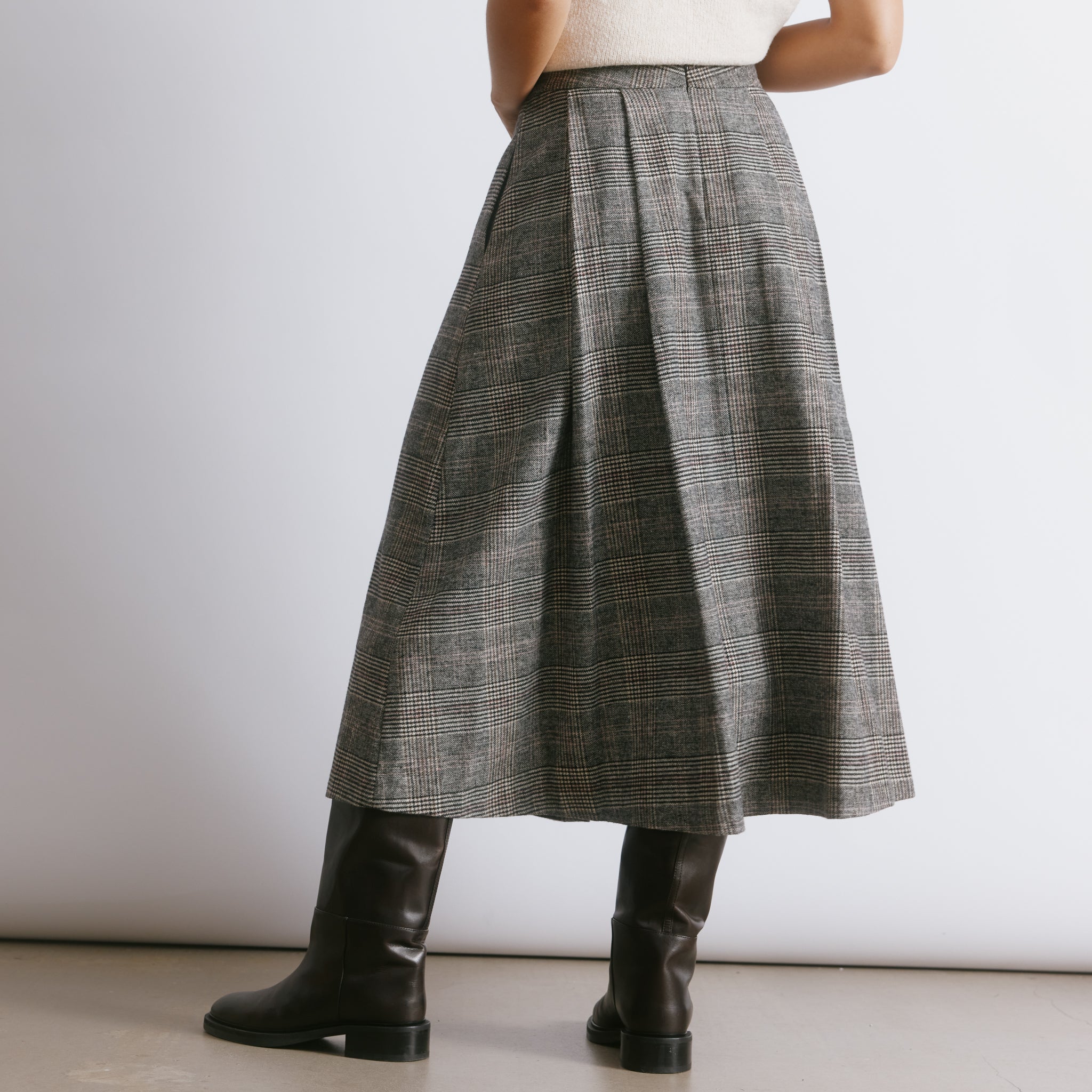 Check midi skirt with a fitted waist and deep structured pleats, creating a flattering silhouette for autumn winter.  