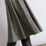 Structured pleated check skirt designed as a versatile statement piece, perfect for day to evening wear.  