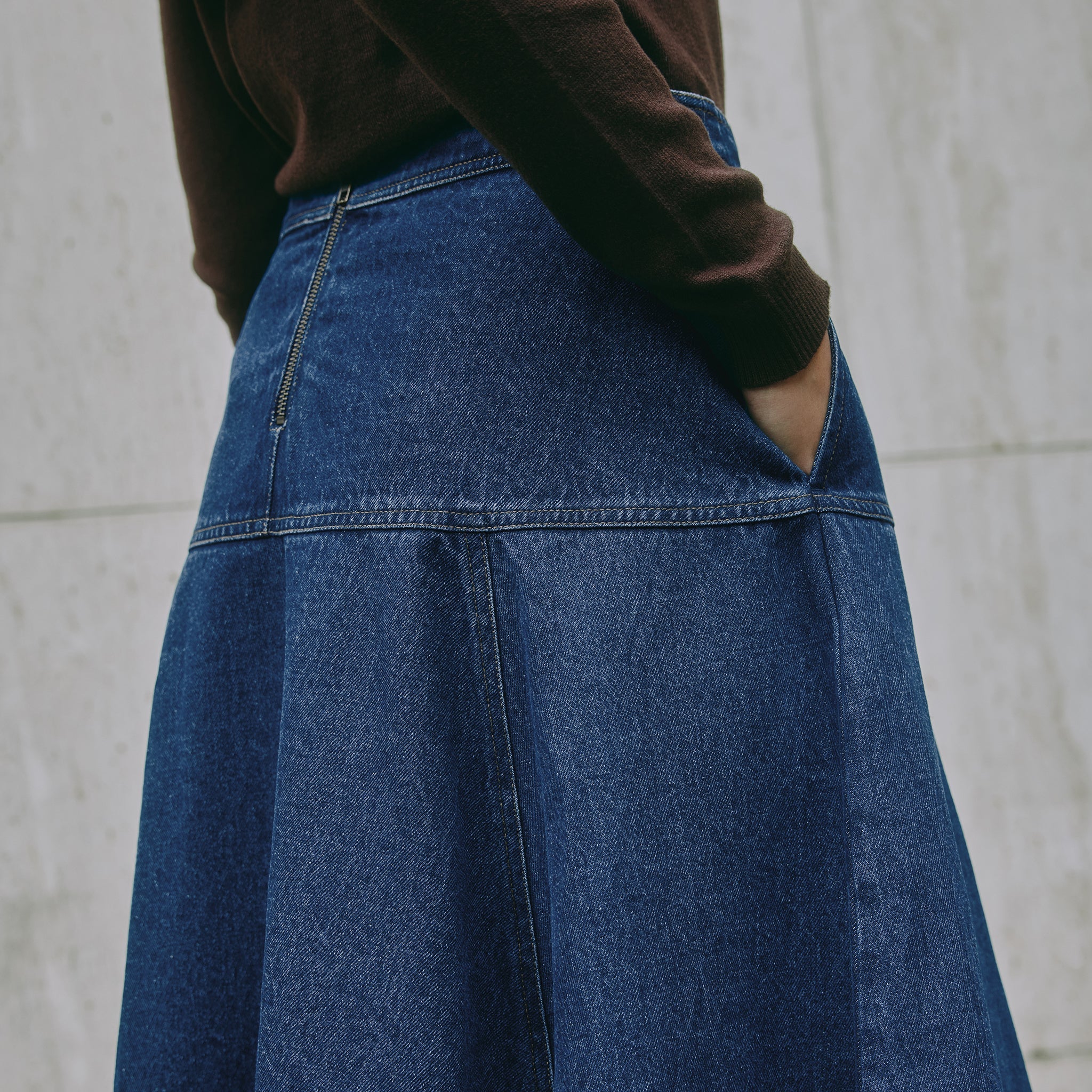 Casual A-line indigo denim skirt showing drop waist and detailed contrast stitching, highlighting eco-friendly sustainable denim.