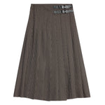 Detailed shot of houndstooth pleated skirt highlighting buckle and pleat craftsmanship, combining classic style with modern tailoring.