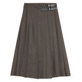 Detailed shot of houndstooth pleated skirt highlighting buckle and pleat craftsmanship, combining classic style with modern tailoring.