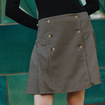 Houndstooth mini skirt detail showing pleats and wrap front, pelmet style tailored skirt, heritage check fabric, sustainable woven skirt