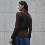 Chocolate knit polo with long sleeves, button placket, and collared neckline in luxe organic cotton blend.