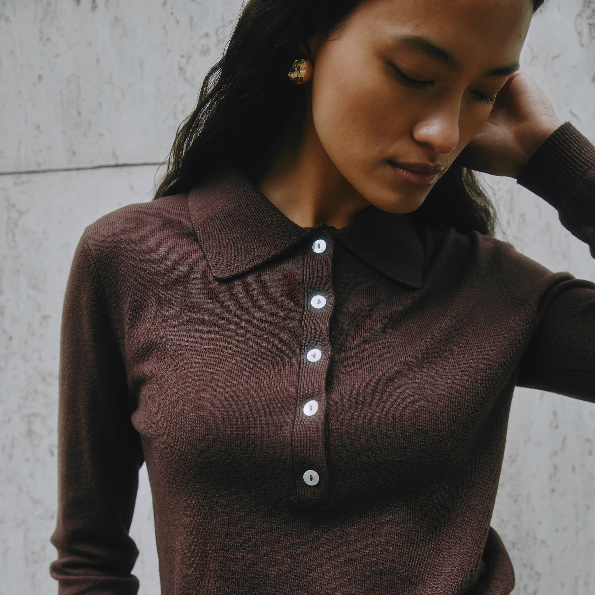 Close-up of chocolate knit polo collar and button details showing premium cashmere blend fabric.
