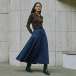 Model wearing chocolate knit polo sweater styled with casual denim, highlighting sustainable knitwear design.
