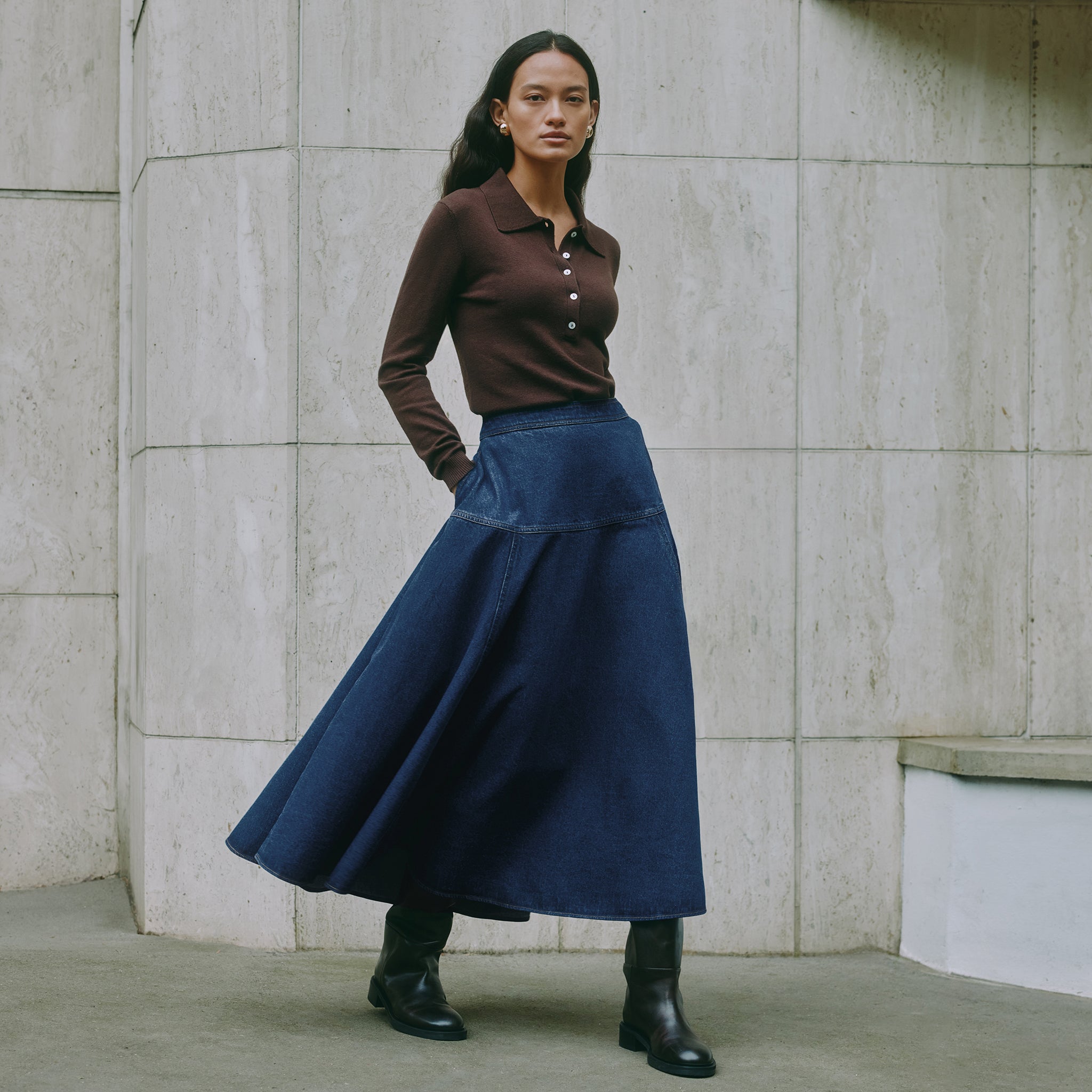 Model wearing chocolate knit polo sweater styled with casual denim, highlighting sustainable knitwear design.