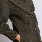 Tailored tweed wool jacket featuring horn buttons and an elegant oversized silhouette.  