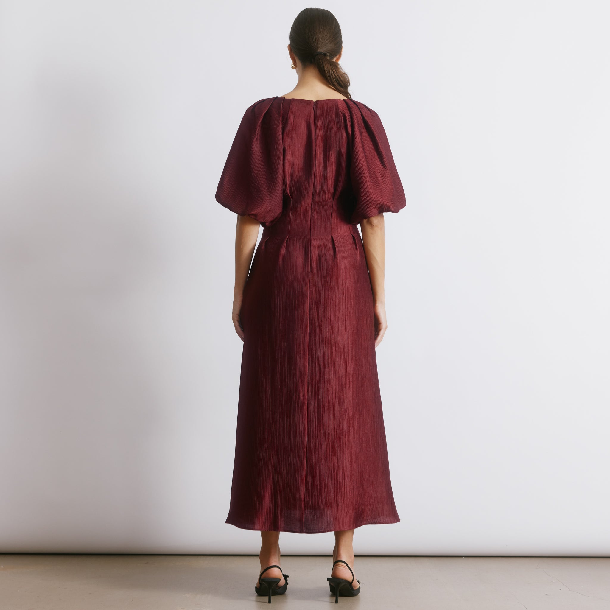 Burgundy crinkle satin dress in elegant long sleeve midi silhouette  