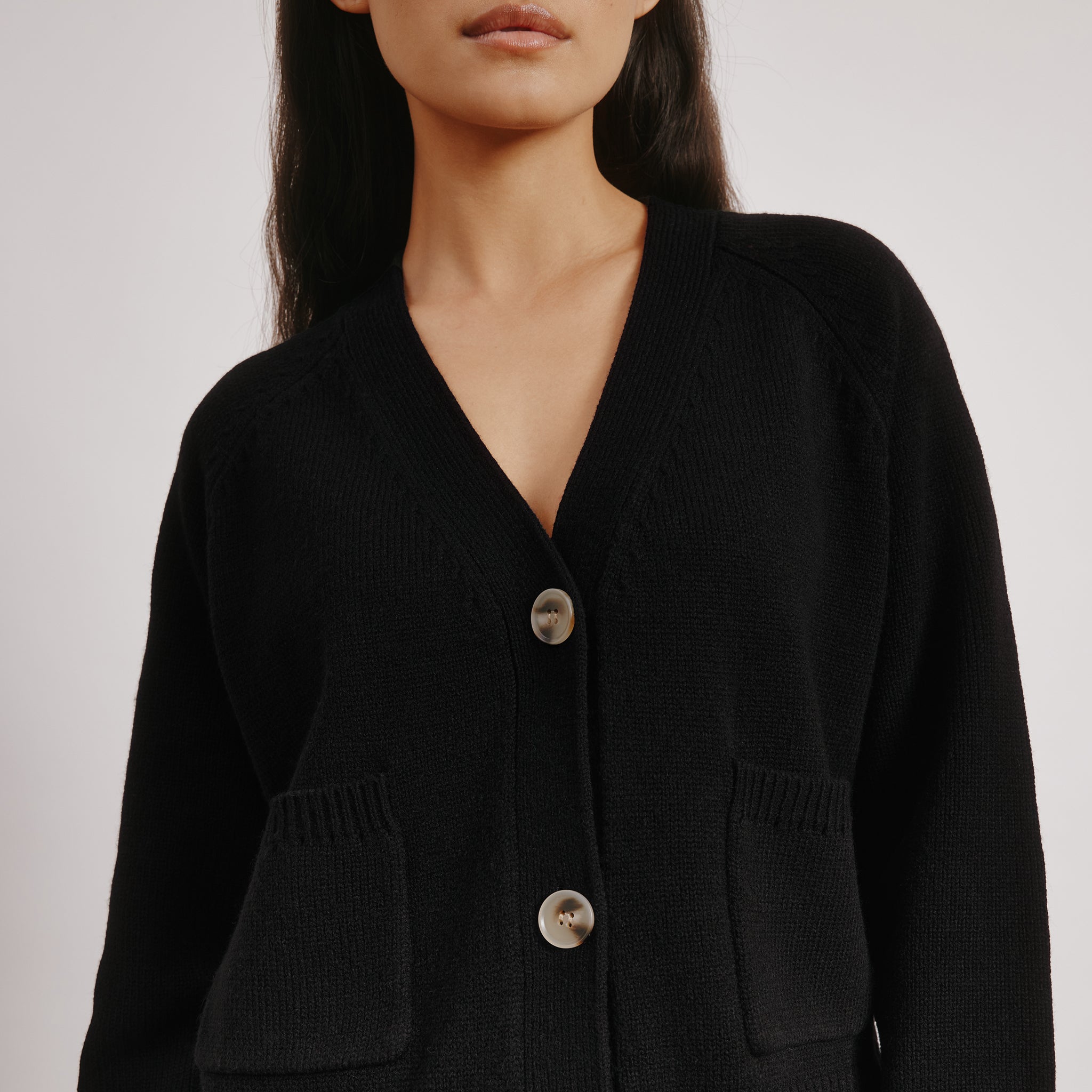 Black wool blend cardigan styled with front pockets for everyday wear  