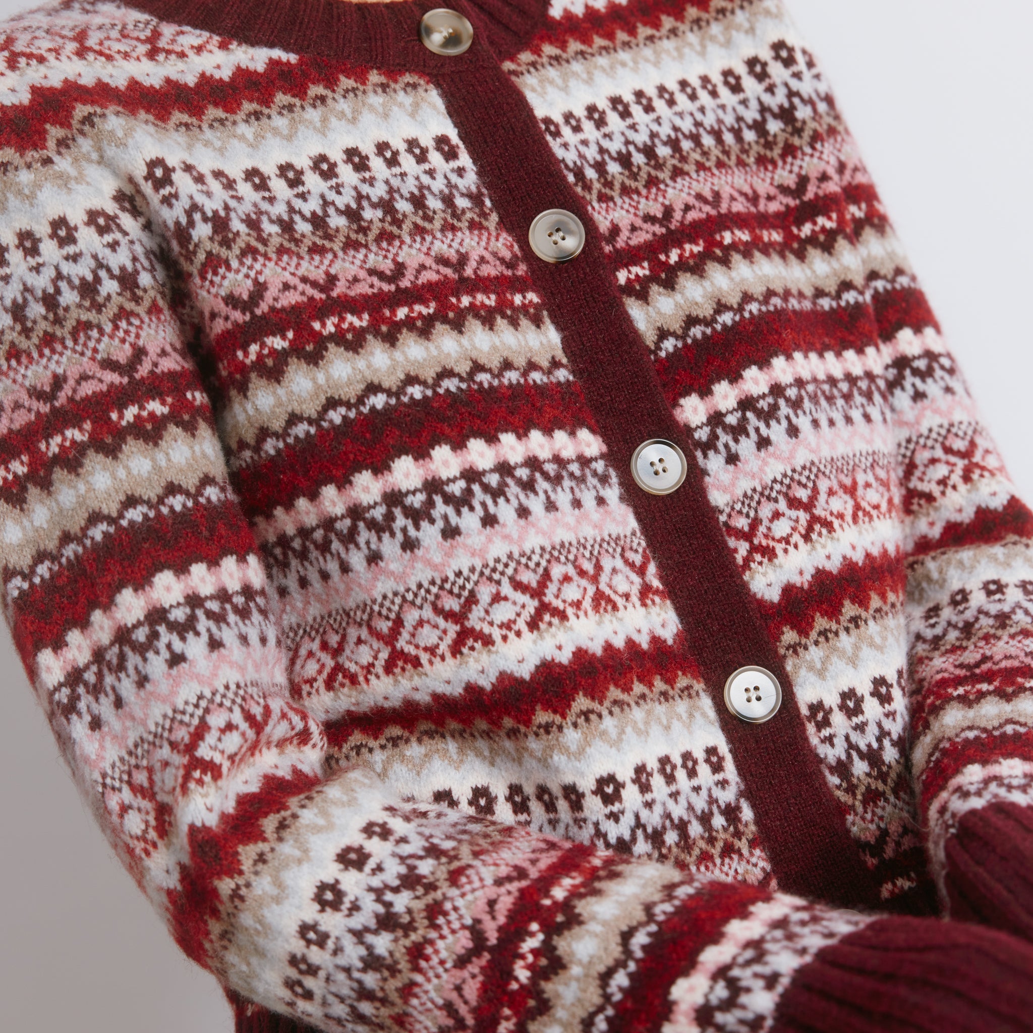 Burgundy fair isle knit styled as a short cosy wool cardigan  