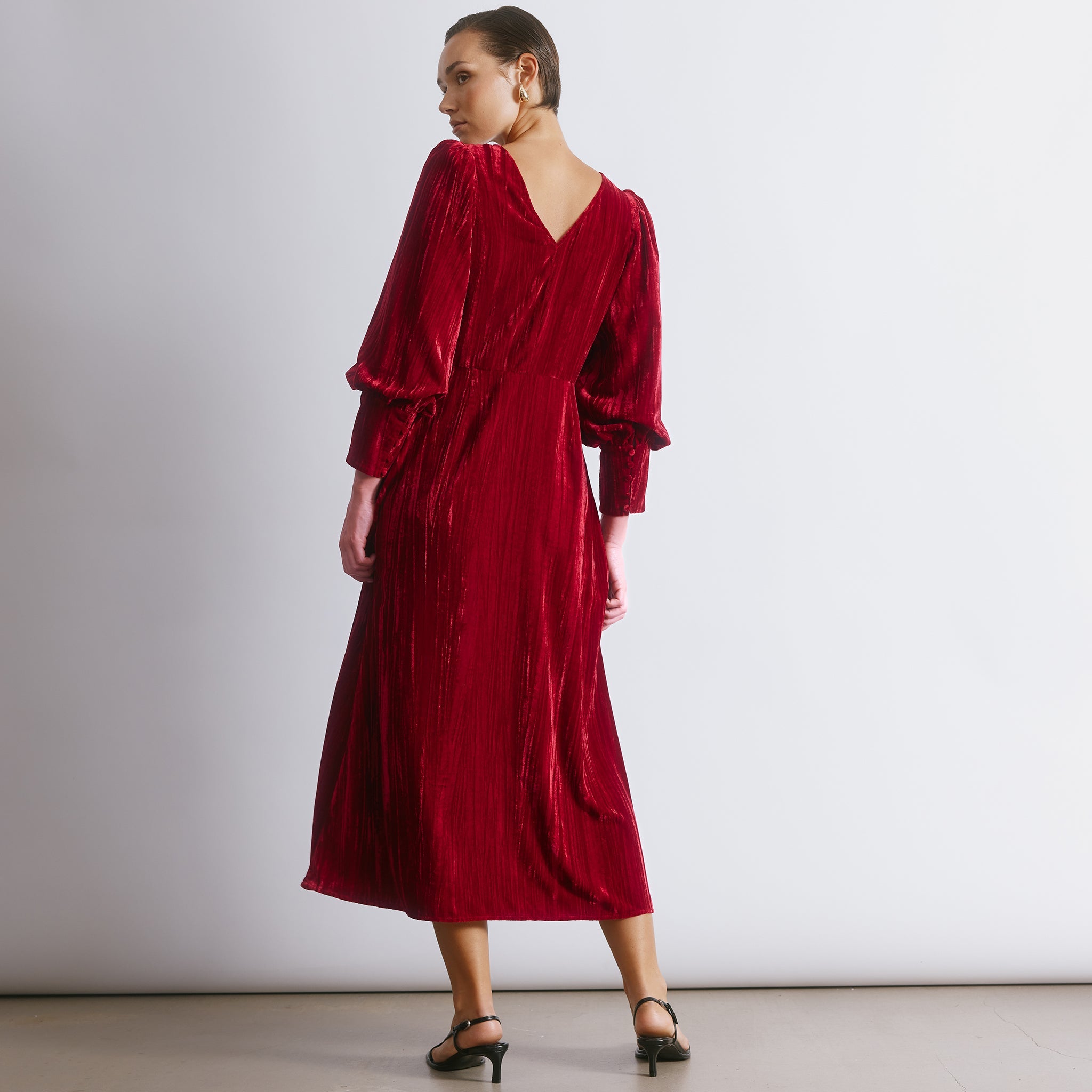 Red velvet dress with a luxurious crushed texture and elegant slash neckline for evening occasions.  