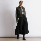 Recycled polyester black skirt featuring classic pleats and a versatile midi length for everyday elegance.  