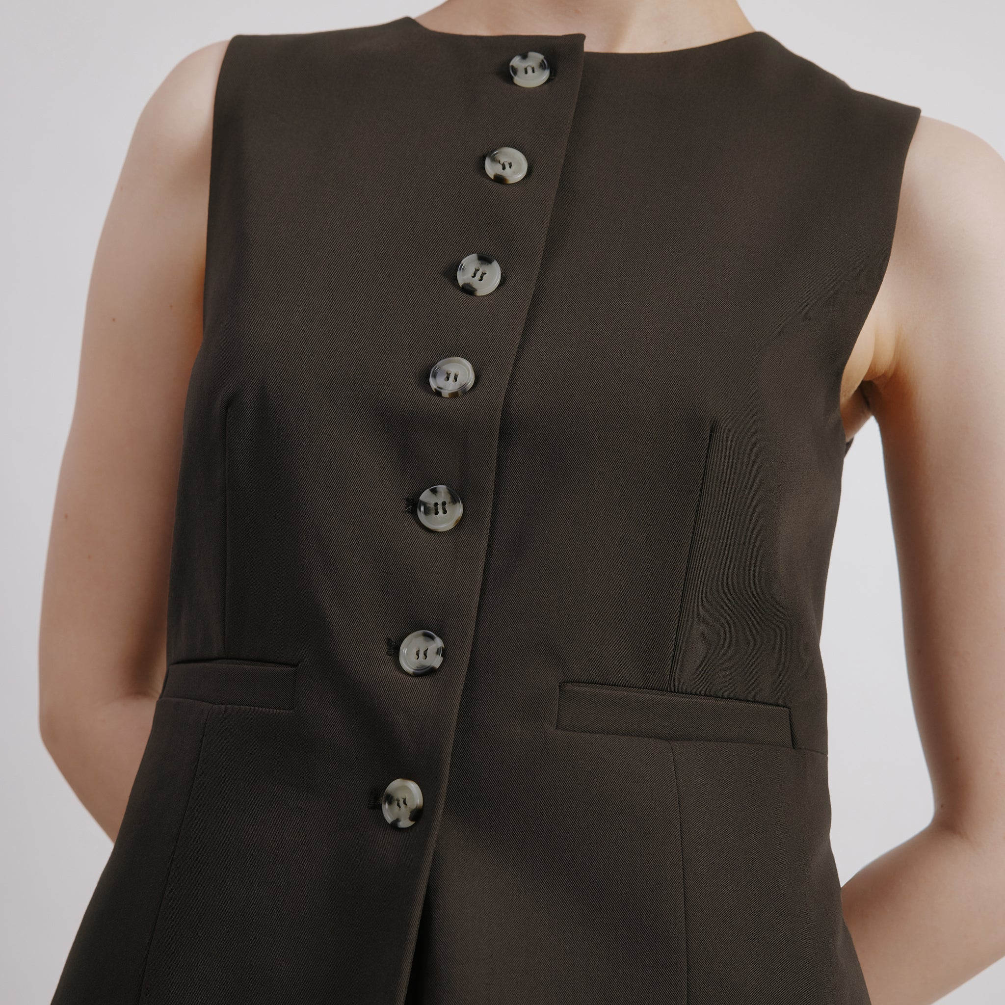 Close-up of the chocolate brown vest showcasing the button front and textured fabric, mock horn button waistcoat, eco-friendly tailoring.