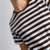 Close-up view of the chocolate stripe tee showing contrast collar and sustainable cotton material.