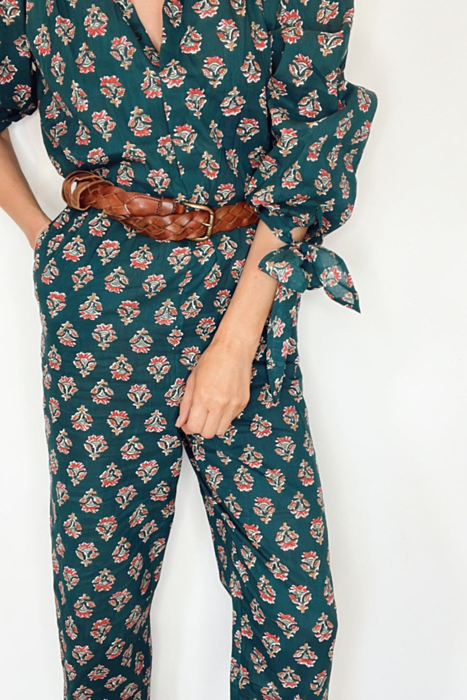 Stylish floral dark green jumpsuit with V neck and elegant tie cuffs on balloon sleeves.