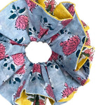 Large green scrunchie with floral design and textured fabric for a unique style.