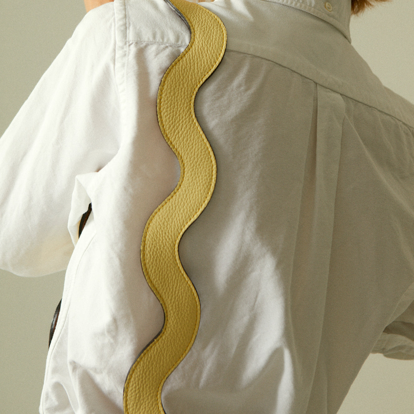 Butter yellow leather handbag with shoulder strap, top view.