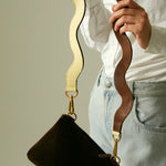 Butter yellow leather handbag with leather shoulder strap, angled view.