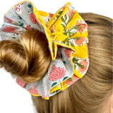 Close-up of floral pattern on a green oversized scrunchie highlighting fabric texture.