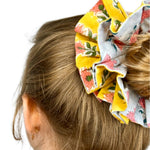 Green oversized scrunchie with floral pattern, perfect for adding color to hairstyles.