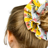 Green oversized scrunchie with floral pattern, perfect for adding color to hairstyles.