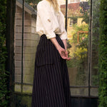 Woman standing in front of a large glass door with a garden view.