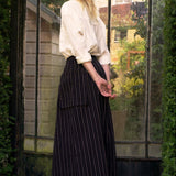 Woman standing in front of a large glass door with a garden view.
