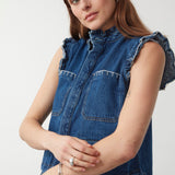 woman wearing a blue denim vest/ waistcoat with our signature white stitch detailing, two large patch pockets, and a frill collar with blue jeans against a white background