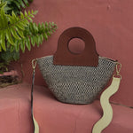 Handheld basket bag made with durable upcycled leather and woven fibers.