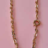 Model wearing a gold plated chunky chain necklace with a prominent front clasp.